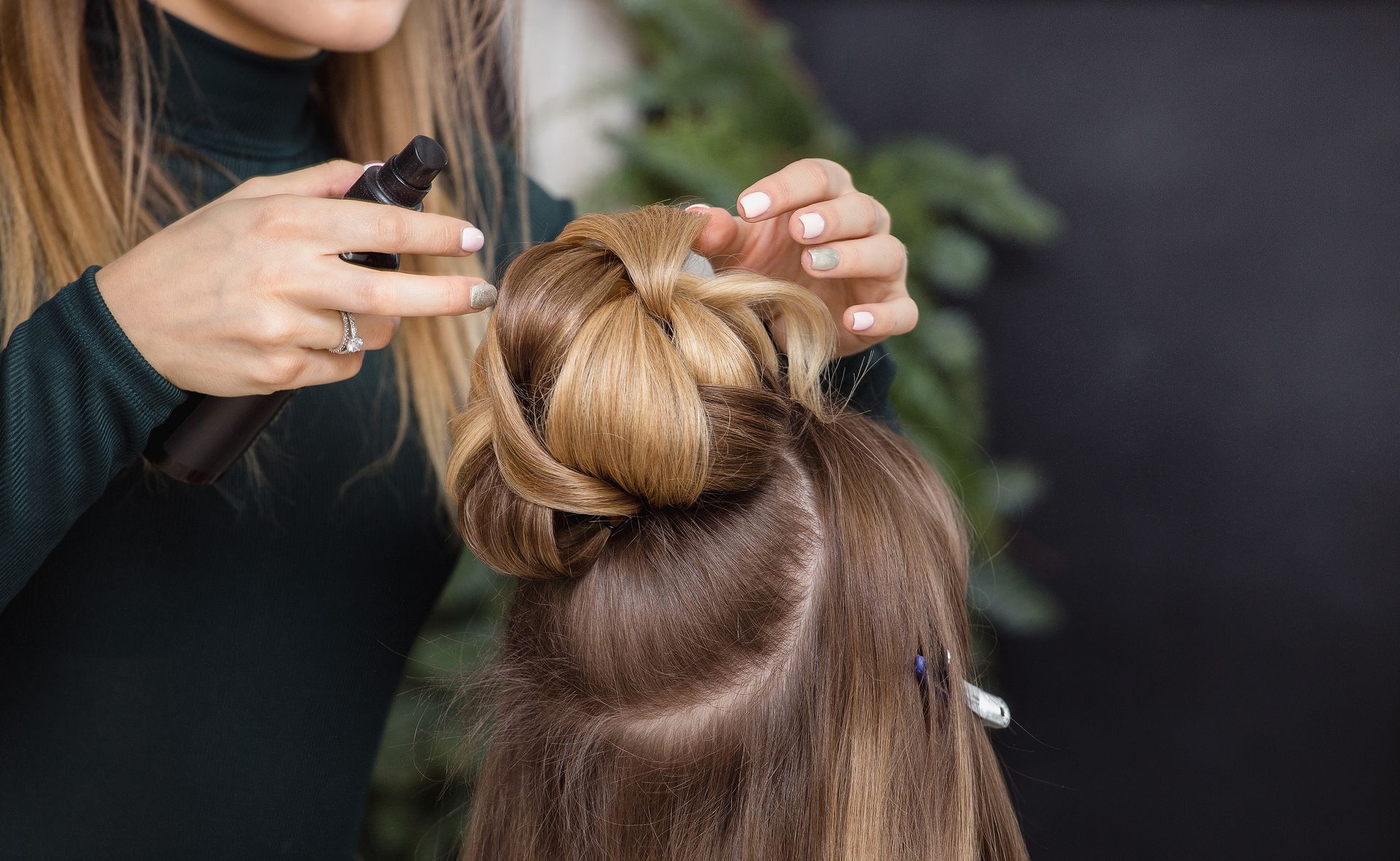Une femme faisant un chignon à une autre femme.