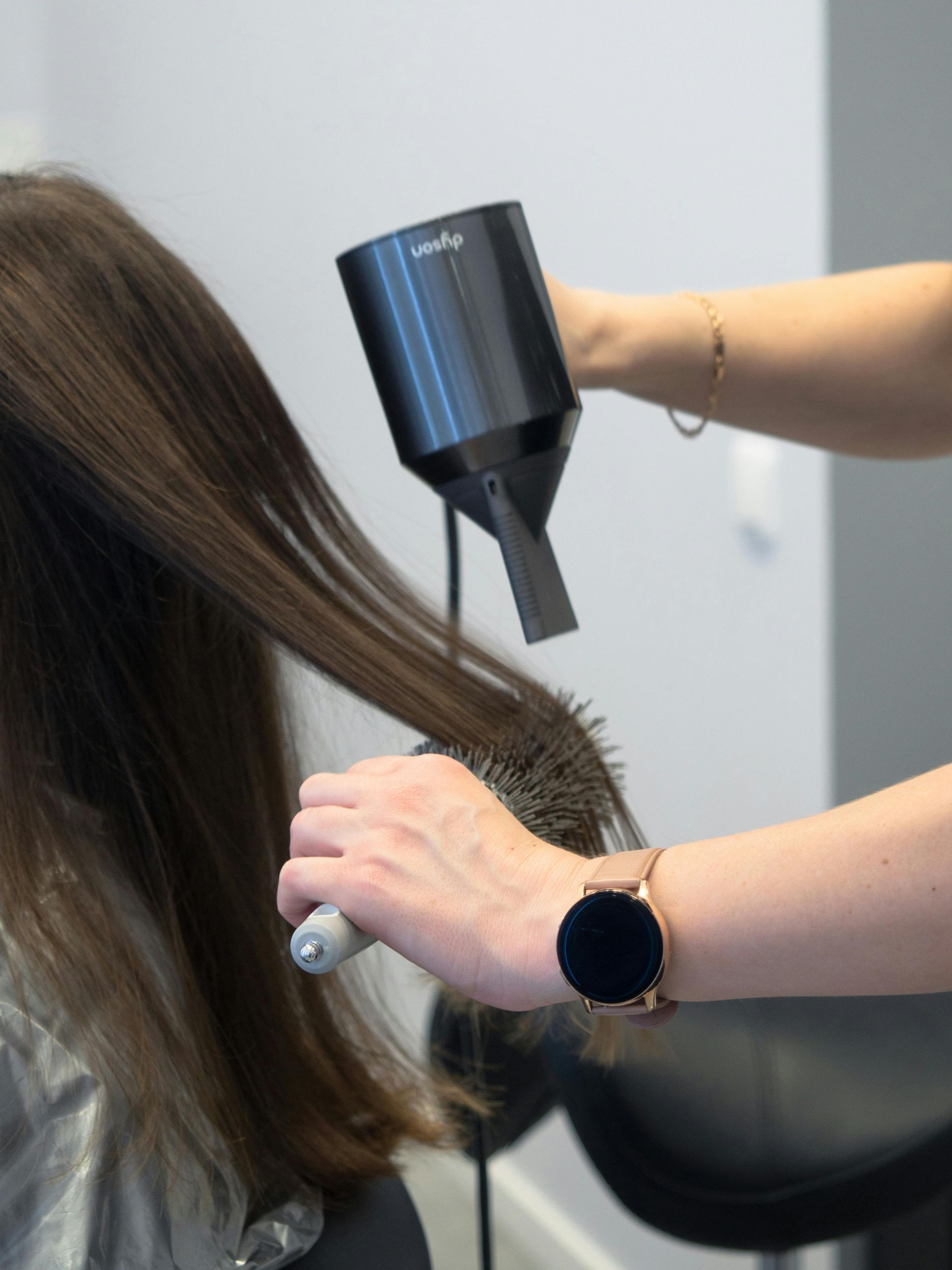 Une personne coupant les cheveux d'un homme.