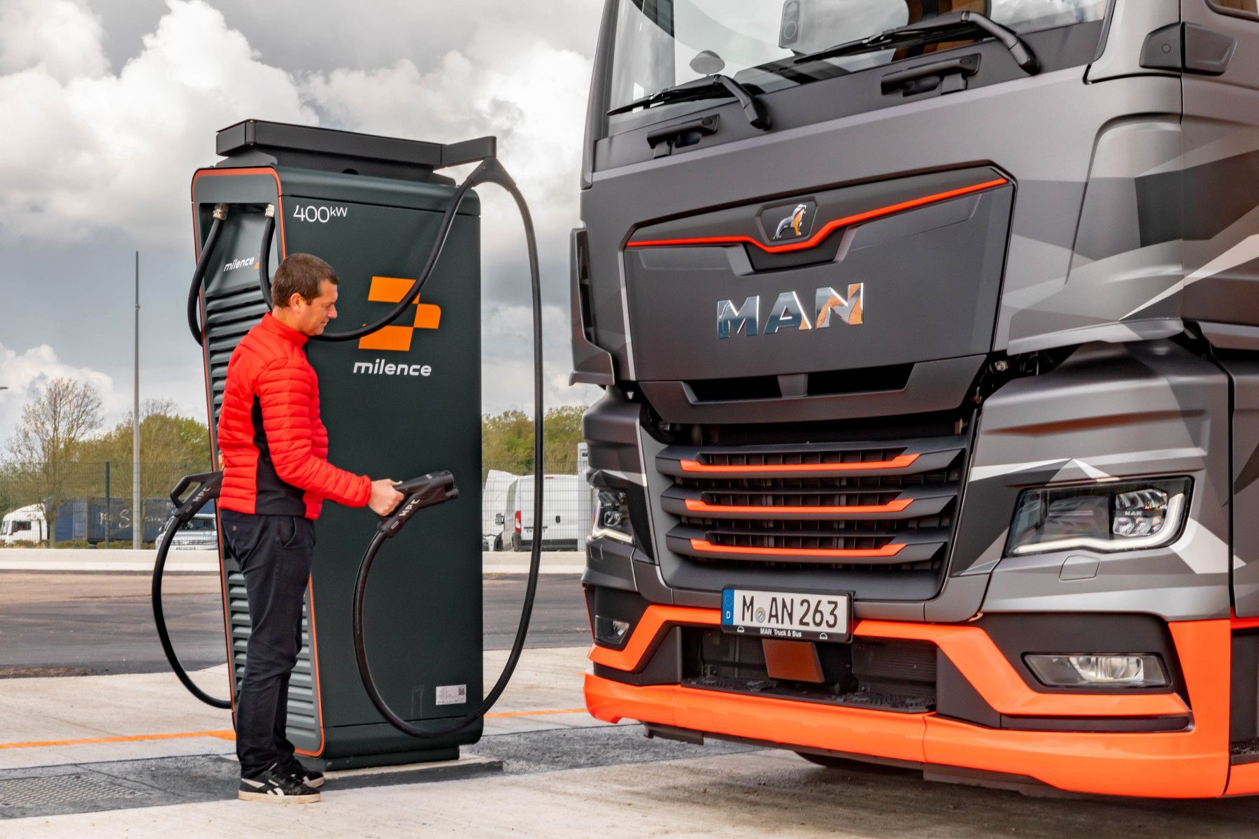Un homme recharge son véhicule électrique