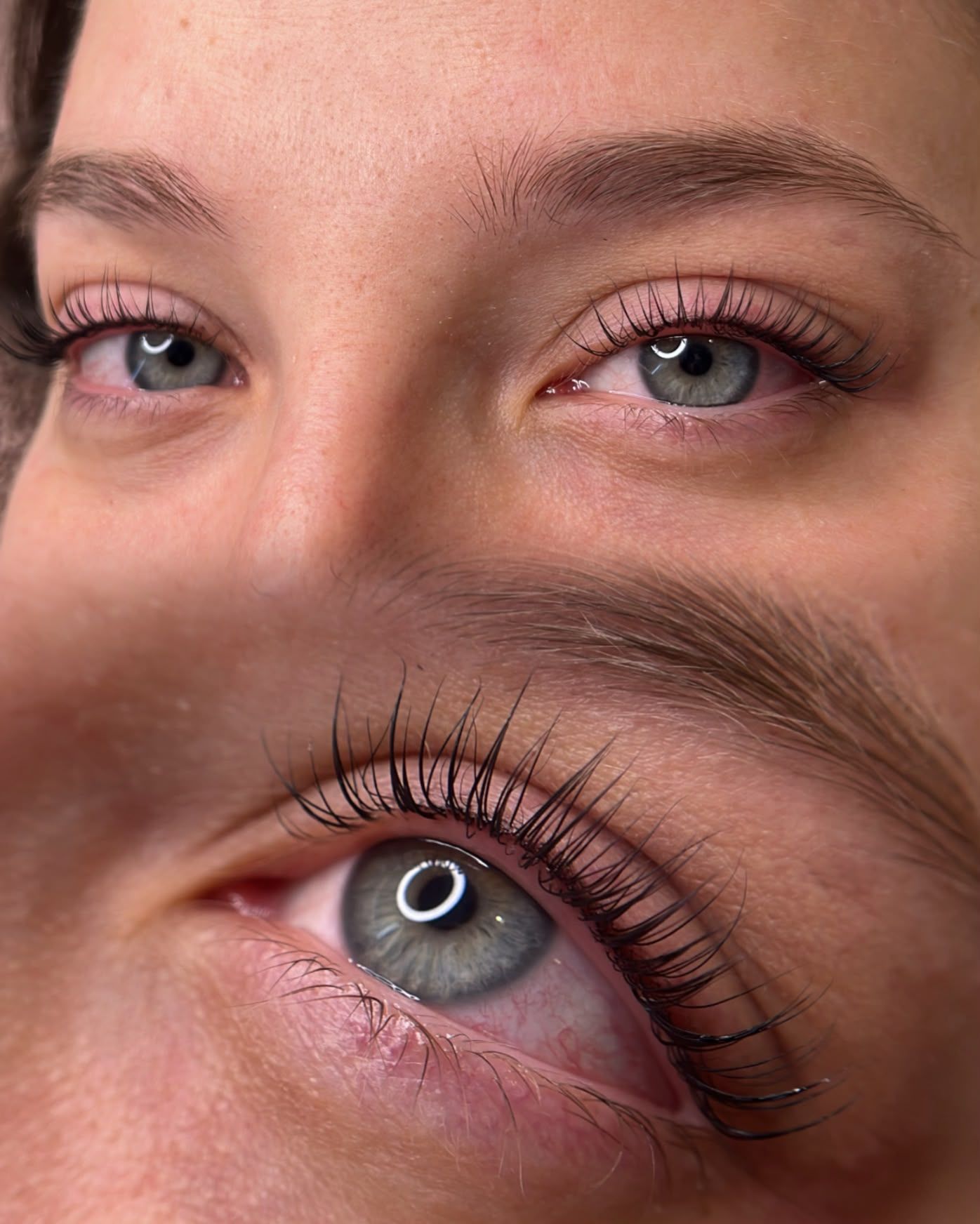 Primer plano de dos ojos, uno con iris azul y el otro cerrado, enmarcados por largas pestañas.