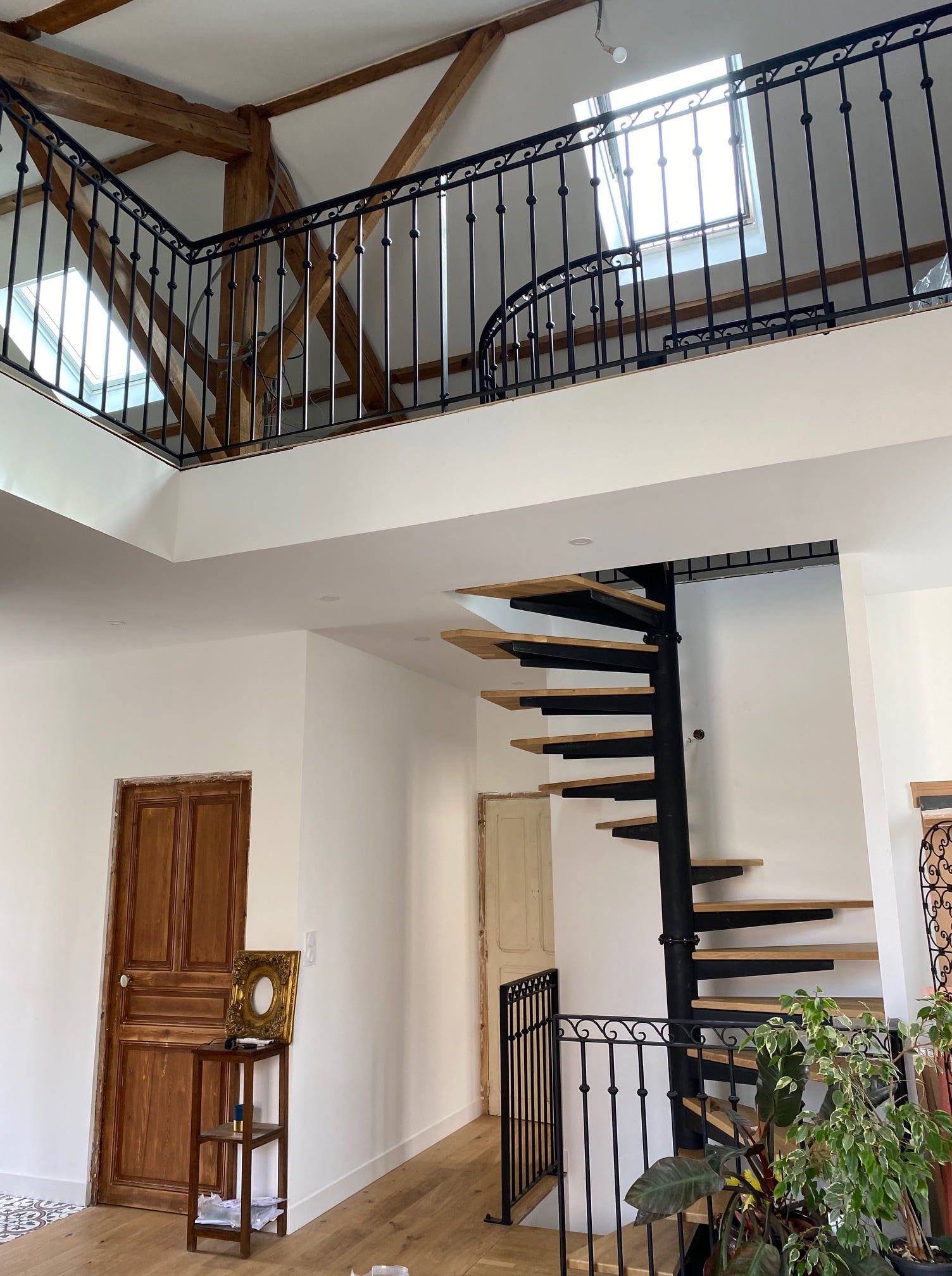 Escalier hélicoïdal carré avec marches bois Garde-corps à barreaudage vertical avec volutes et olives.