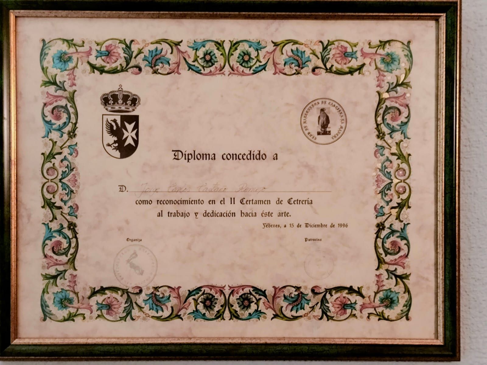 Un diploma está enmarcado en una pared blanca.