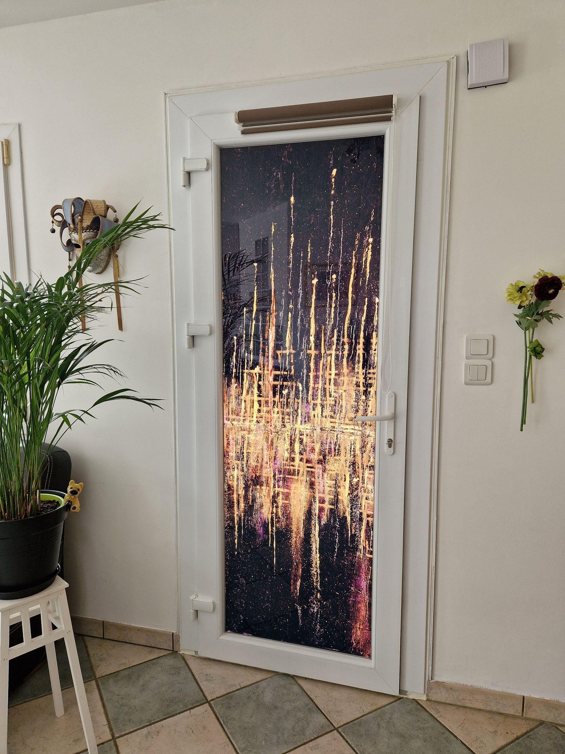 Porte d'entrée avec décoration dorée sur la vitre