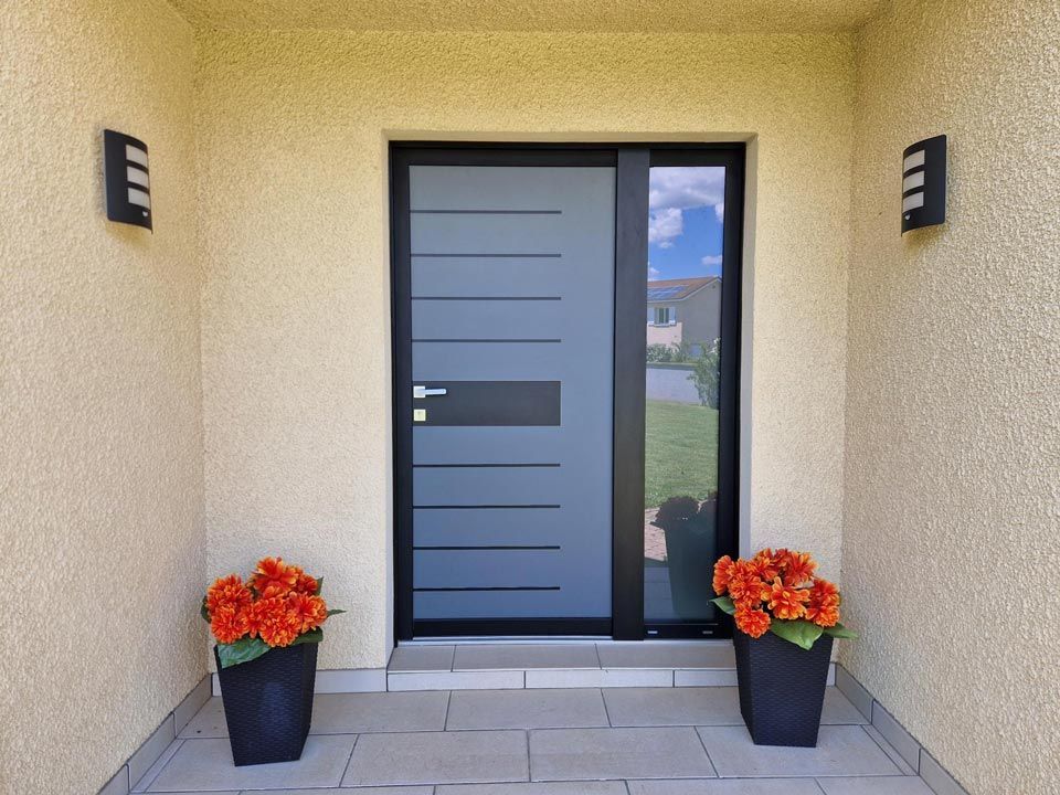 Porte d'entrée moderne en aluminium avec deux pots de fleur