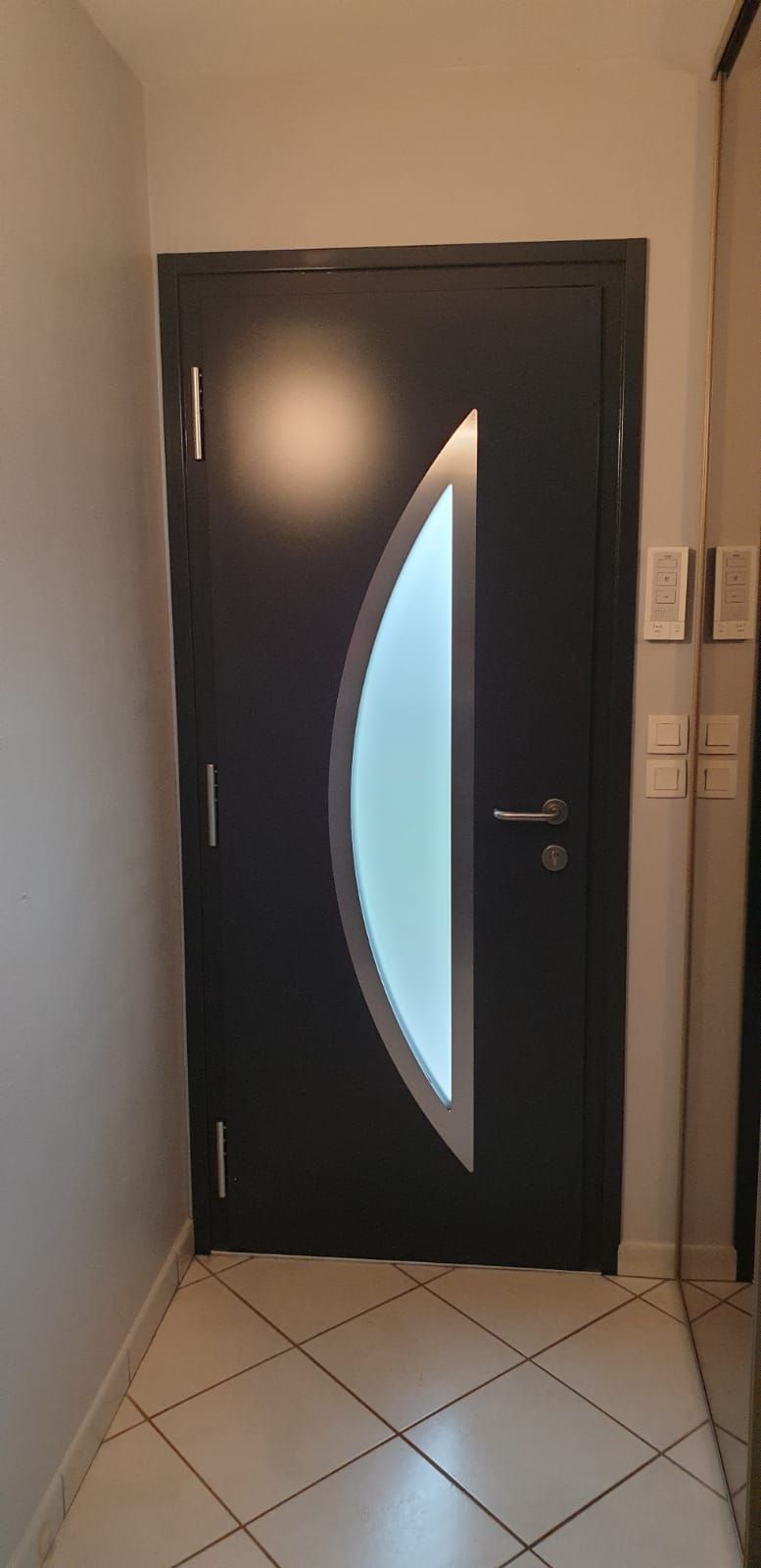 Porte d'entrée grise avec vitre arrondie