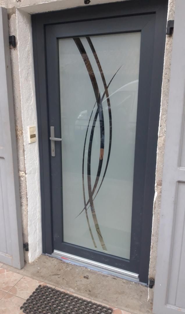 Porte d'entrée vitrée fumée avec décoration abstraite