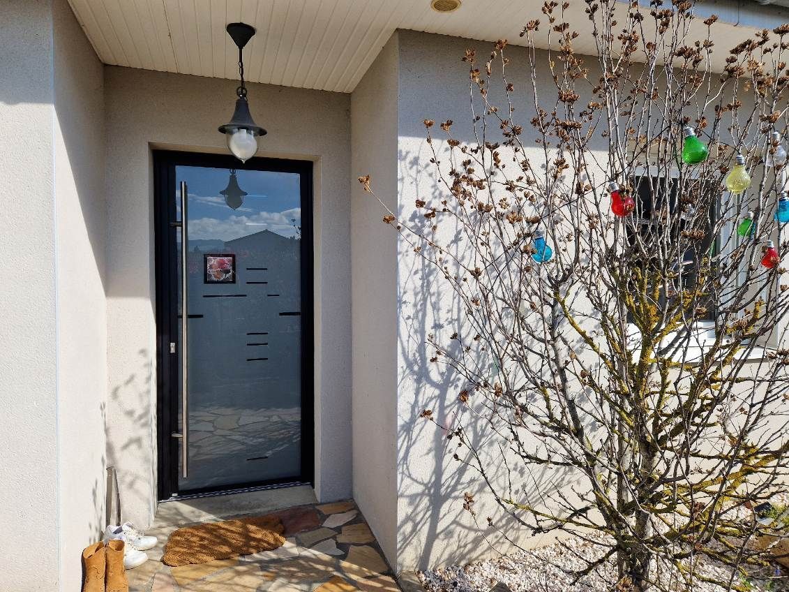 Porte d'entrée vitrée avec une barre verticale pour poignée