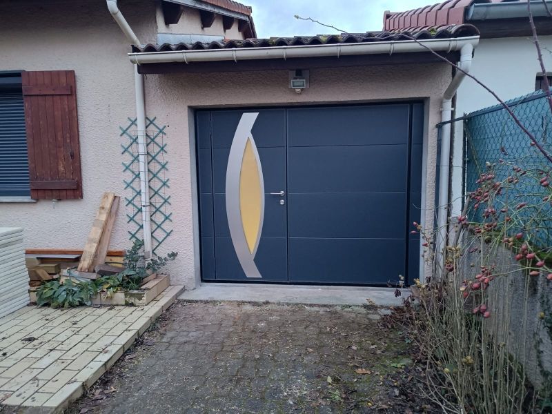 Vue de face d'une maison avec une porte de garage bleu foncé et un panneau décoratif jaune et blanc