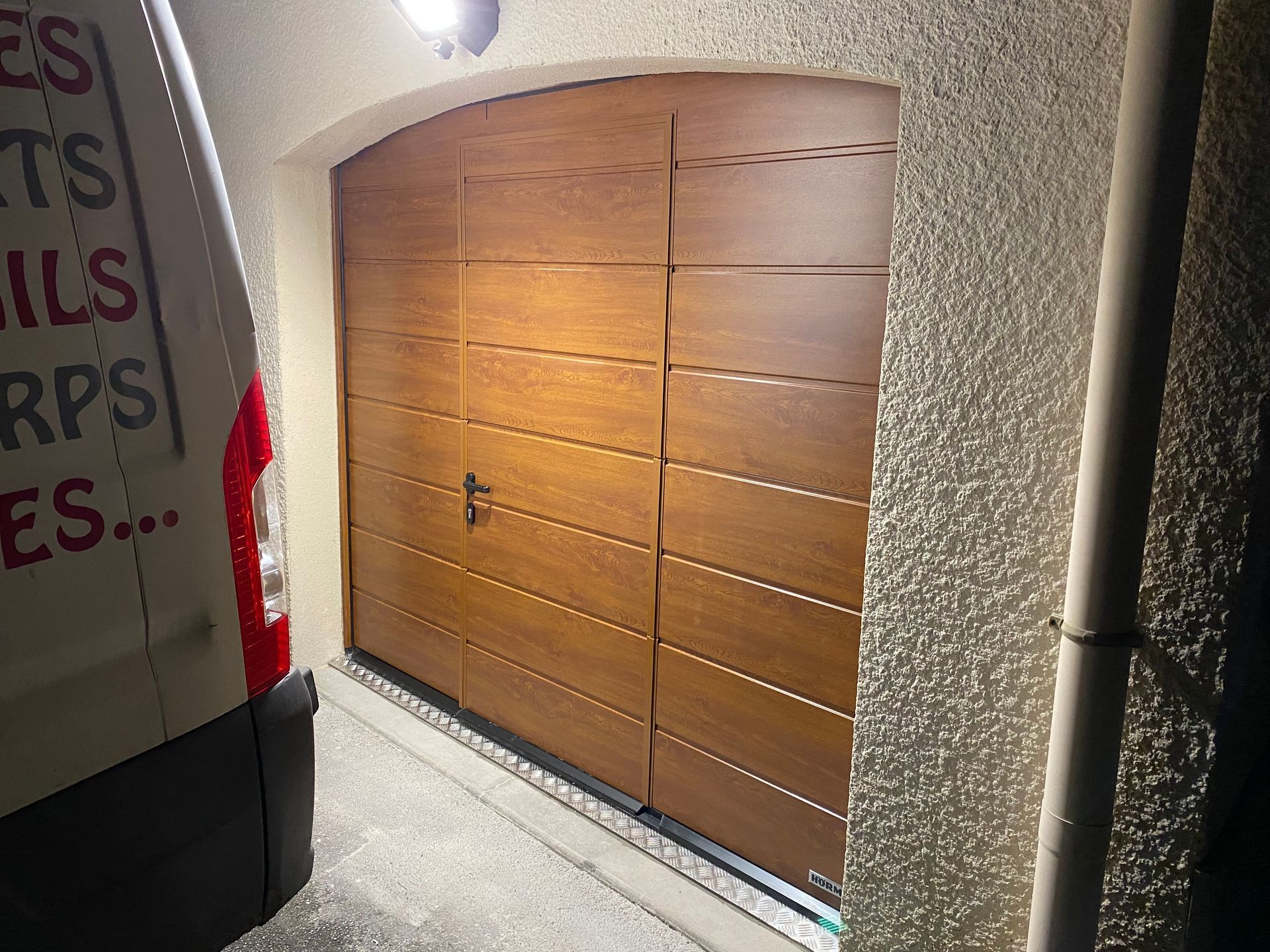 Porte de garage marron avec voiture Acti'Pose à côté