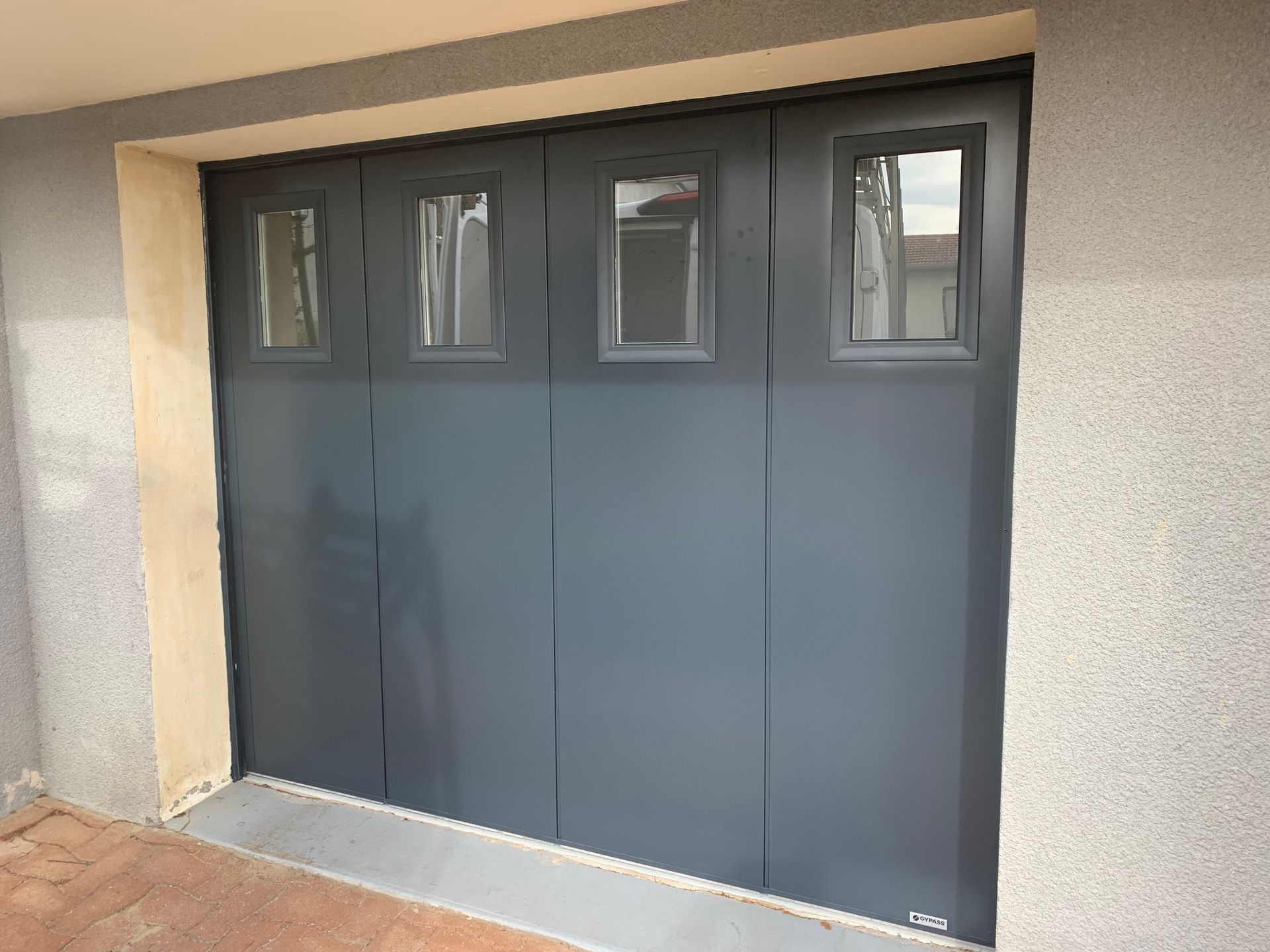 Porte de garage grise avec hublots