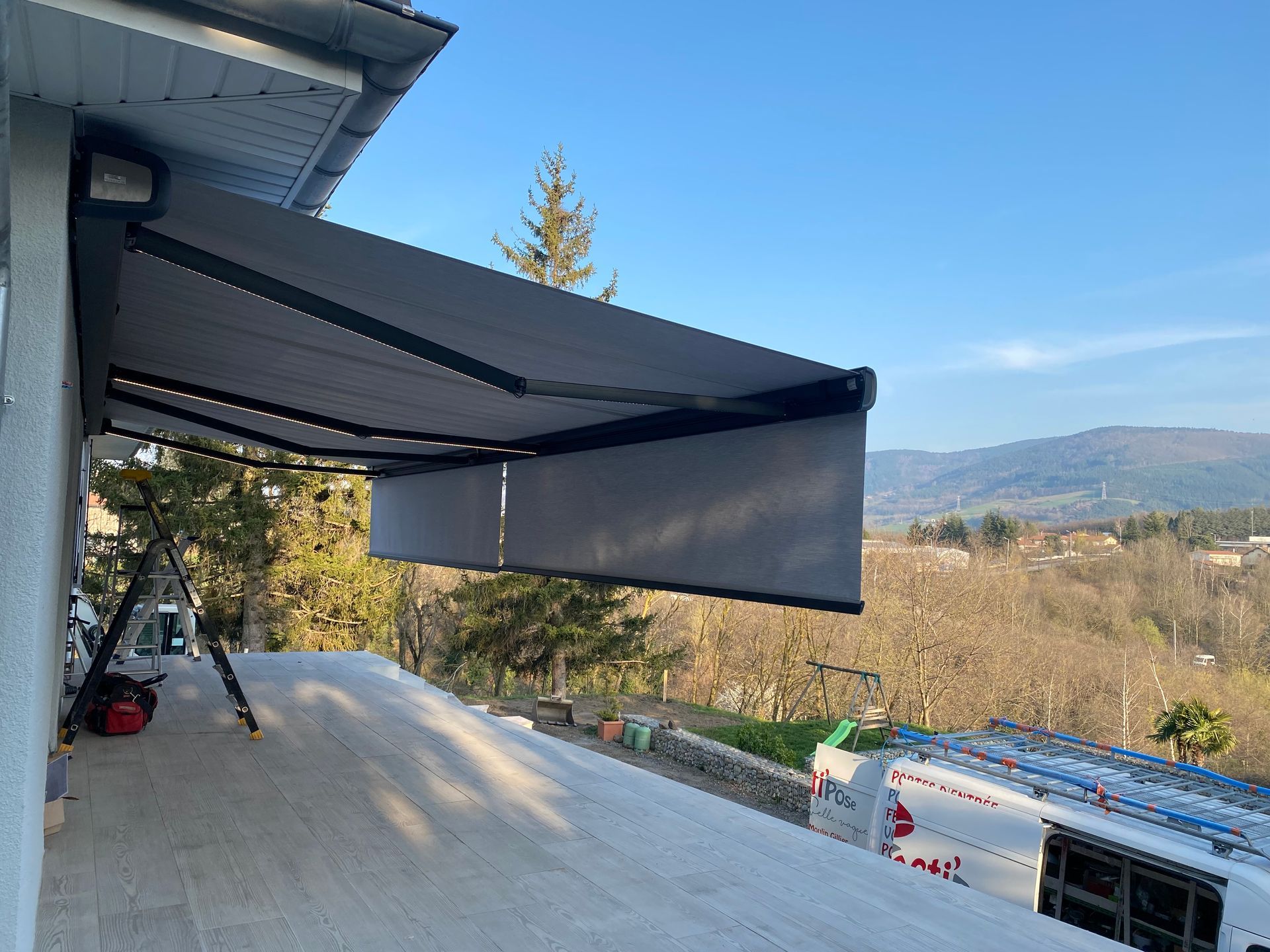 Store banne déployé sur un mur de pierre