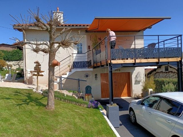 Grand store banne orange sur une terrasse en hauteur