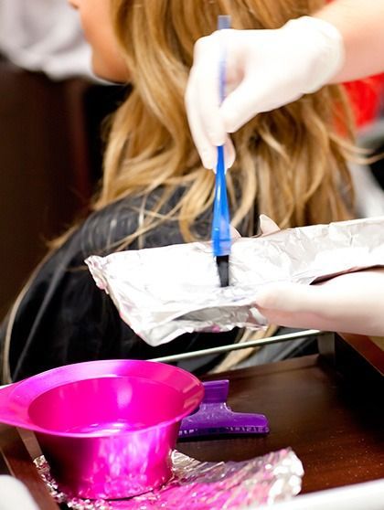 Una mujer se está tiñendo el pelo en un salón
