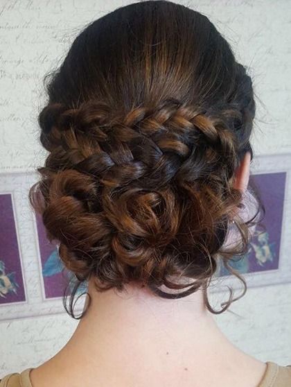 Una mujer lleva el pelo recogido en un moño trenzado.