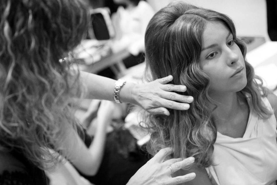 En una foto en blanco y negro, una mujer se está peinando en la peluquería.