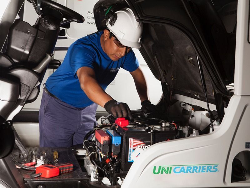 Un hombre está trabajando en una carretilla elevadora unicarriers