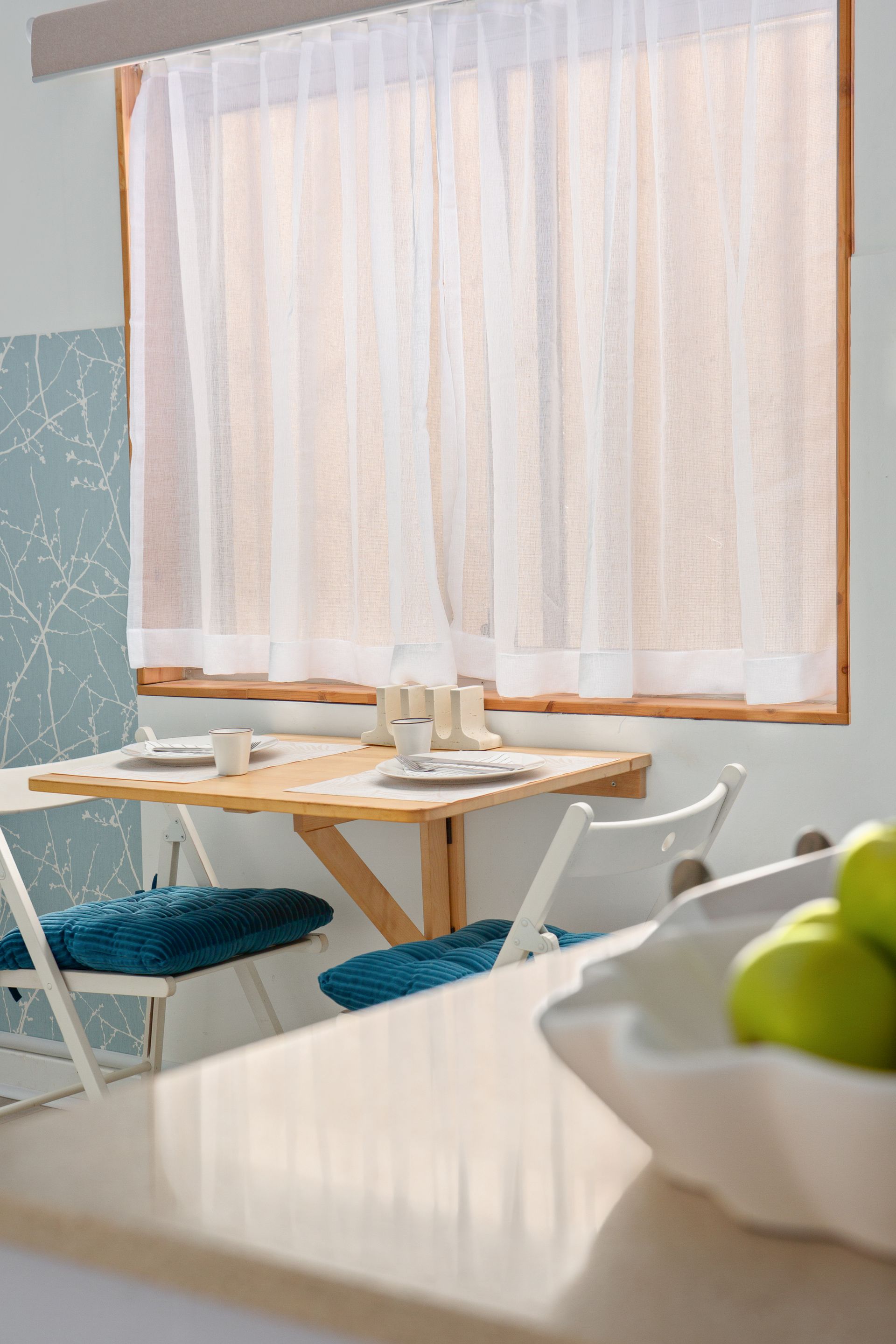 Bright café interior with a window, sheer curtains, and a small table set for two