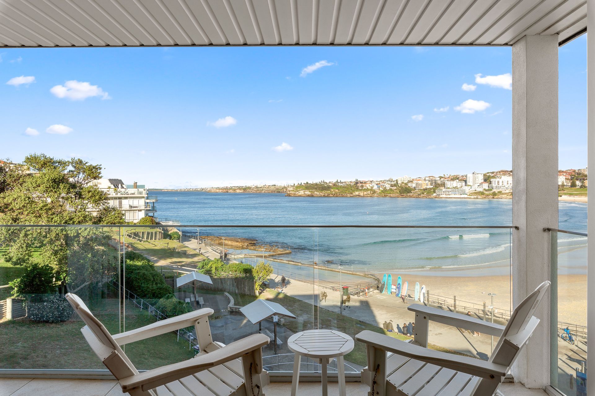 Beachfront balcony with chairs and ocean view on a sunny day