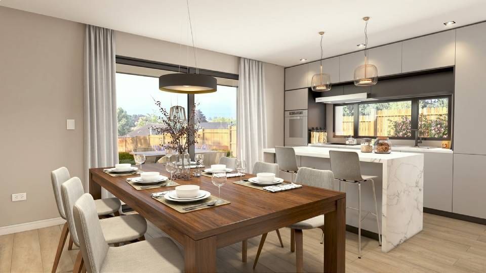 Salle à manger avec table et chaises, communicante avec une cuisine équipée d'un îlot central et de tabourets de bar.