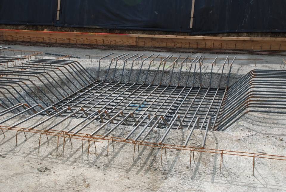 Treillis d'armature en acier dans une fondation en béton, prêt pour le coulage du béton.