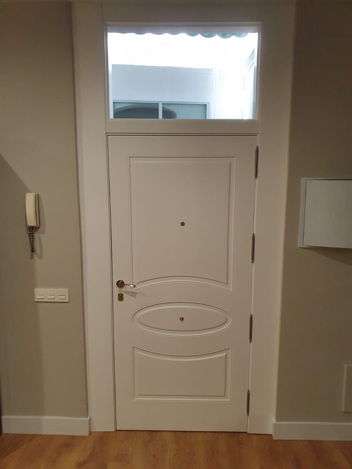Una puerta blanca con una ventana en el medio en una habitación.