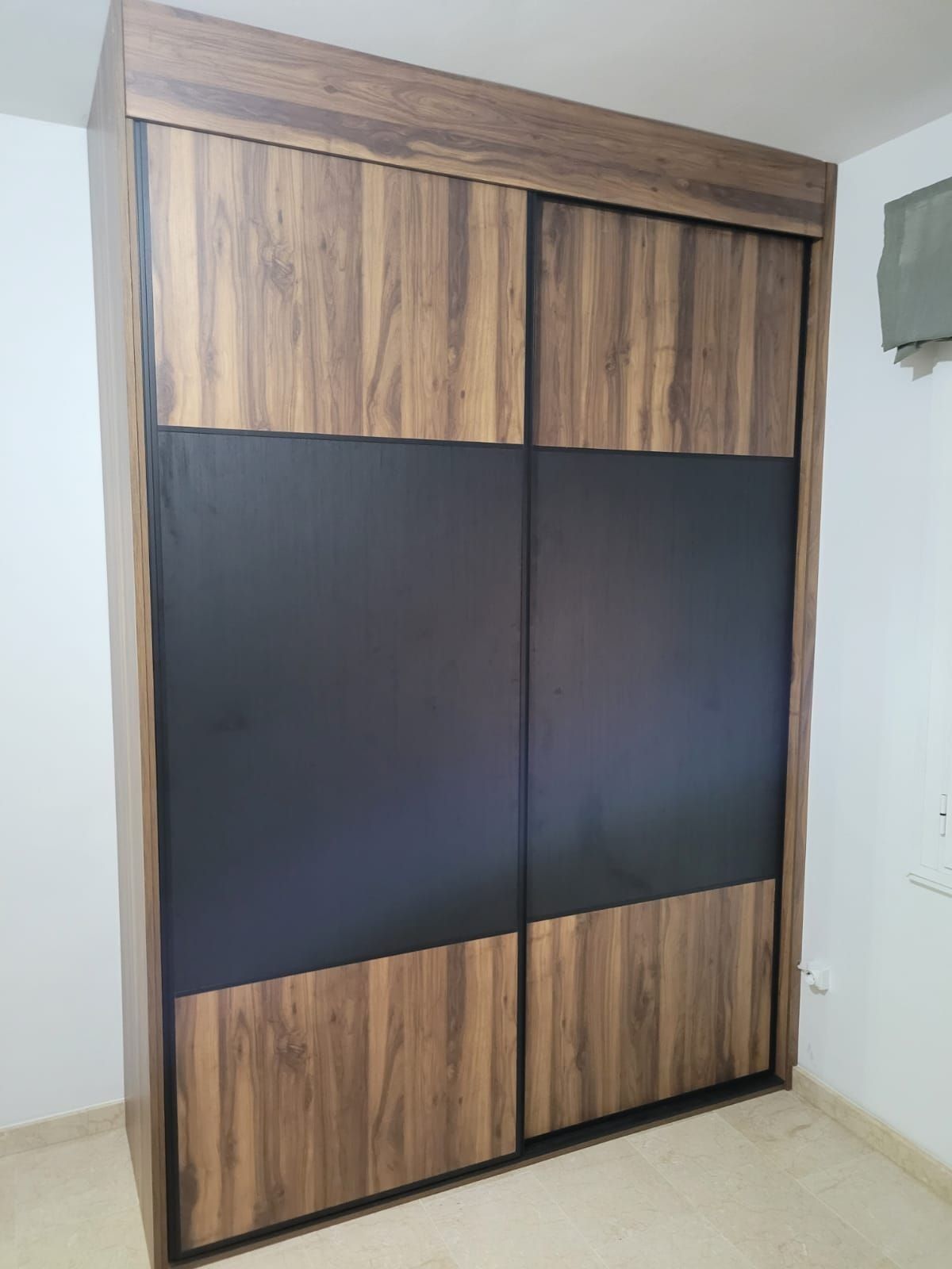 Un gran armario de madera con puertas correderas en un dormitorio.