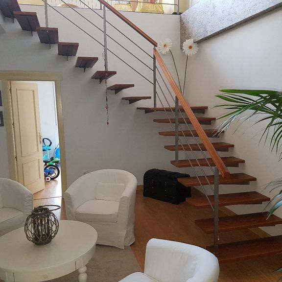 Una sala de estar con escaleras que conducen al segundo piso.