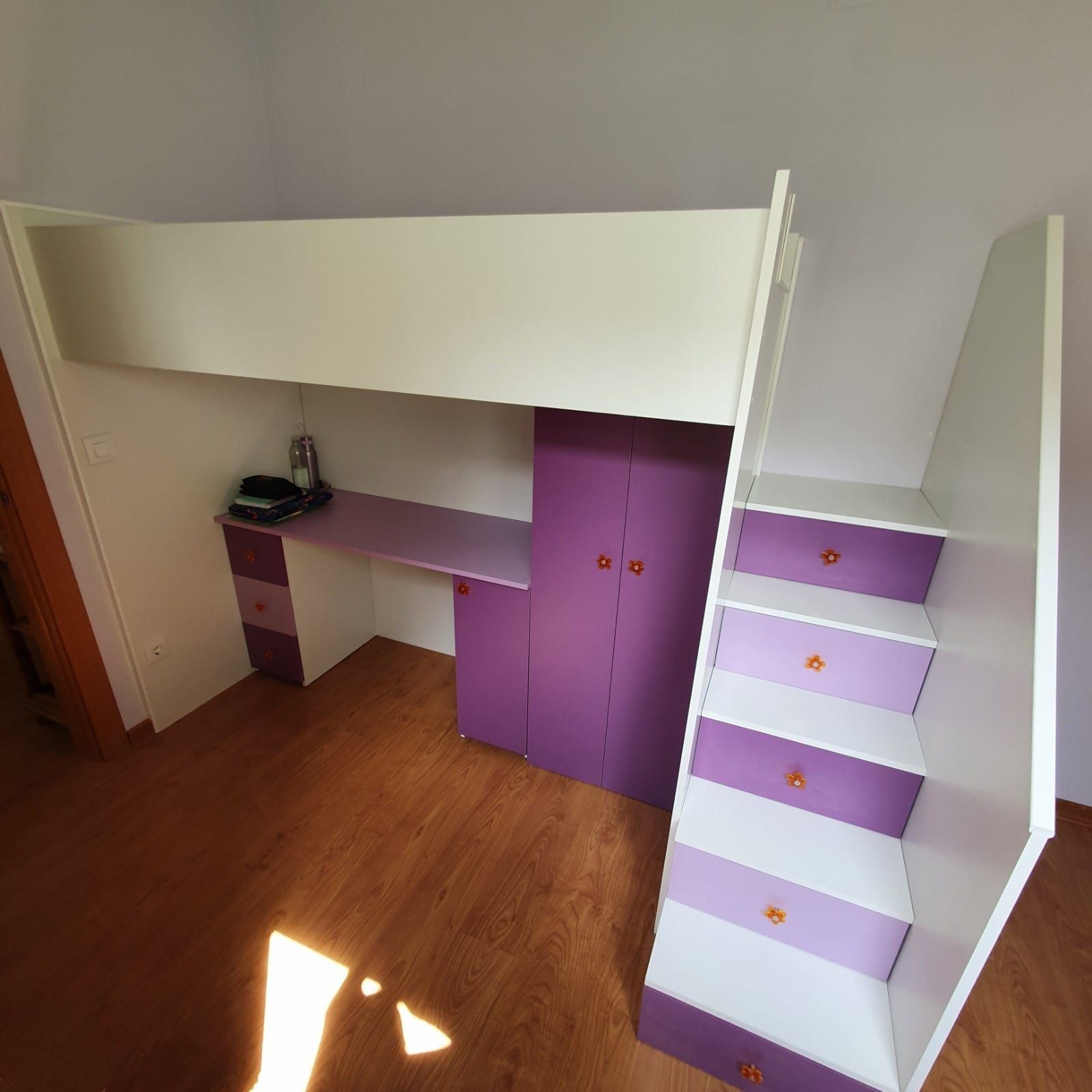 Una litera con armarios morados y escaleras en una habitación.