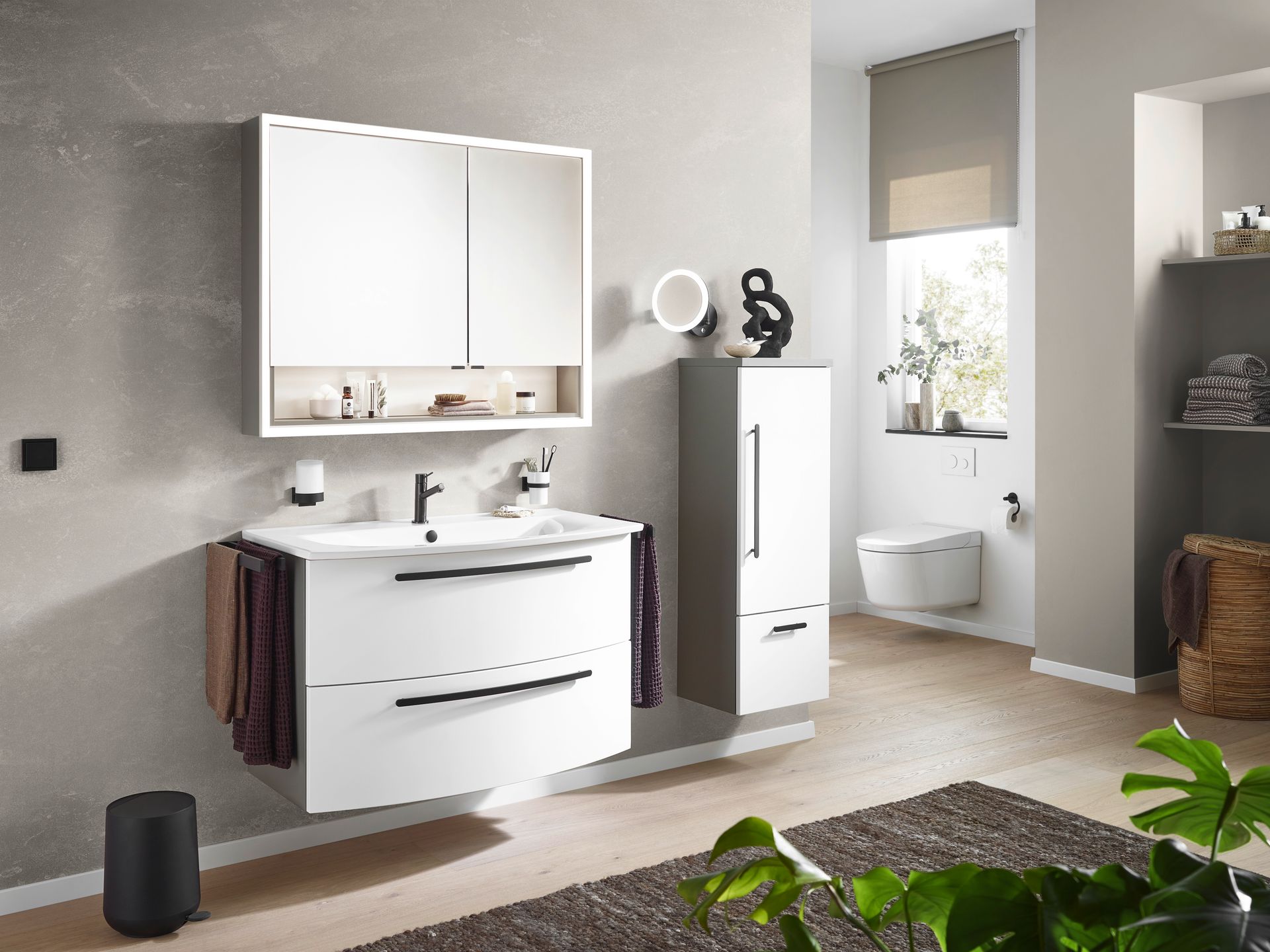 Badezimmer mit Waschtisch, Spiegel und Badewanne in heller Holzoptik.