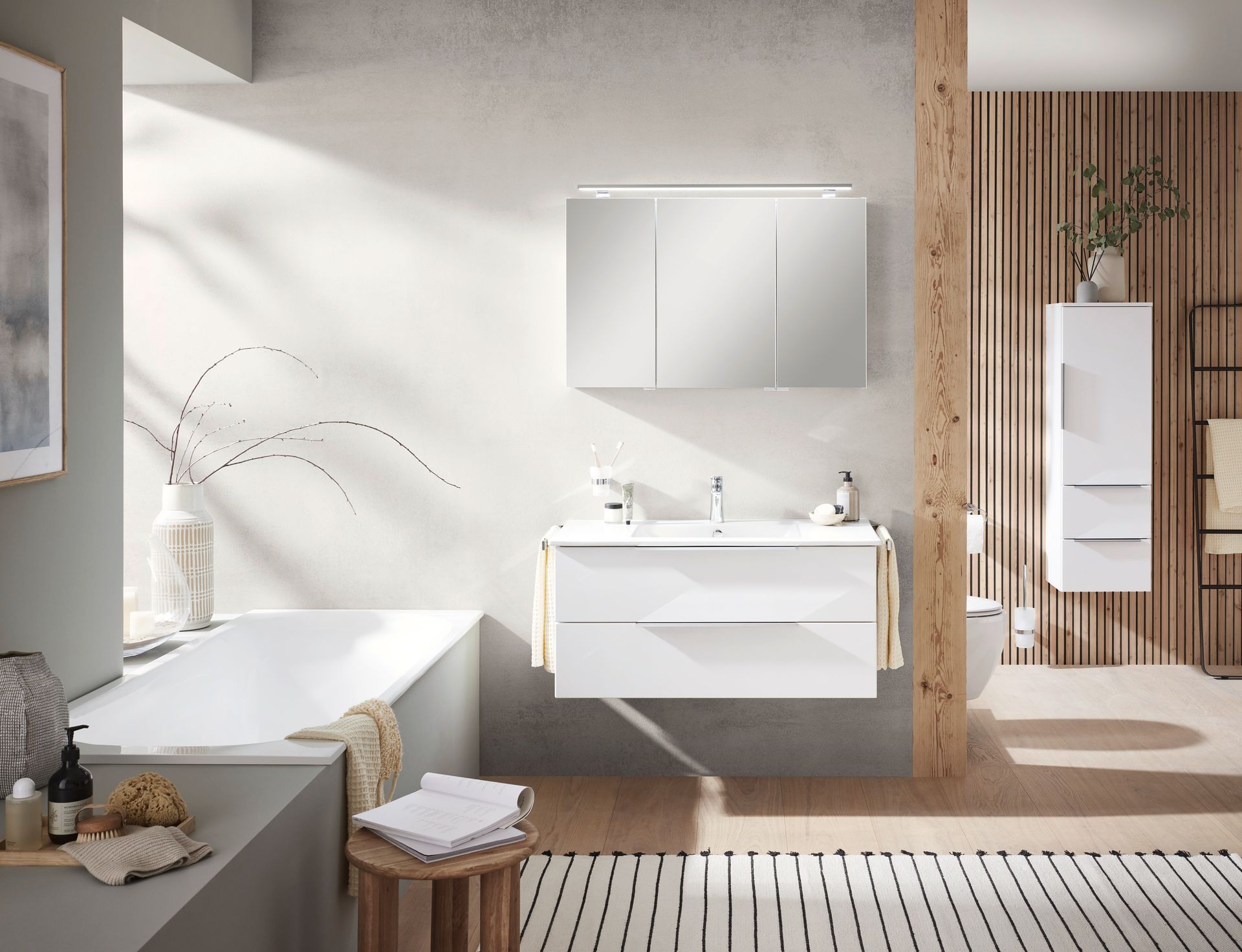 Modernes Badezimmer mit Waschbecken, großem Spiegel und heller Steinwand.