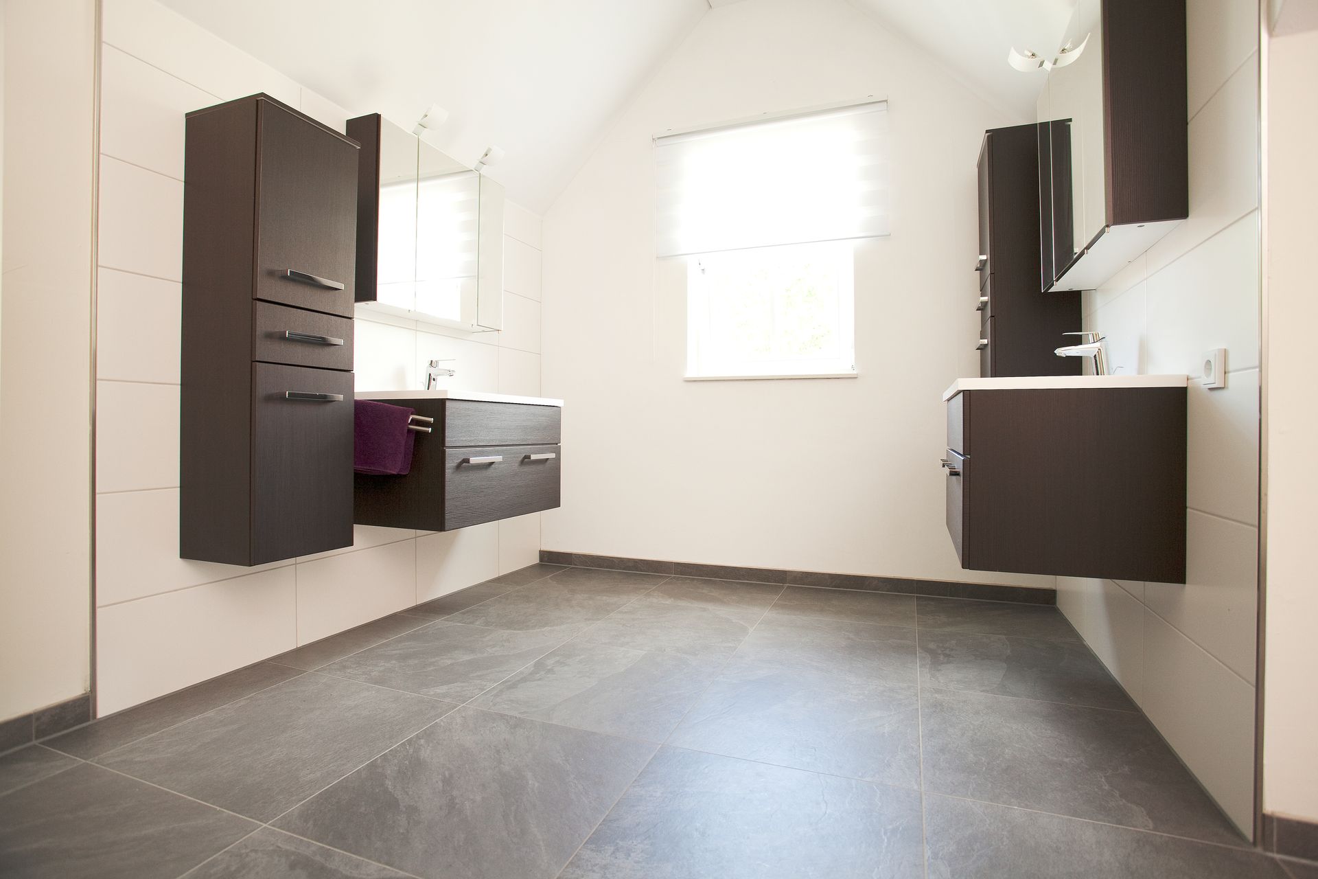 Helles Bad mit Waschtisch, Spiegel und geräumigem Grundriss.