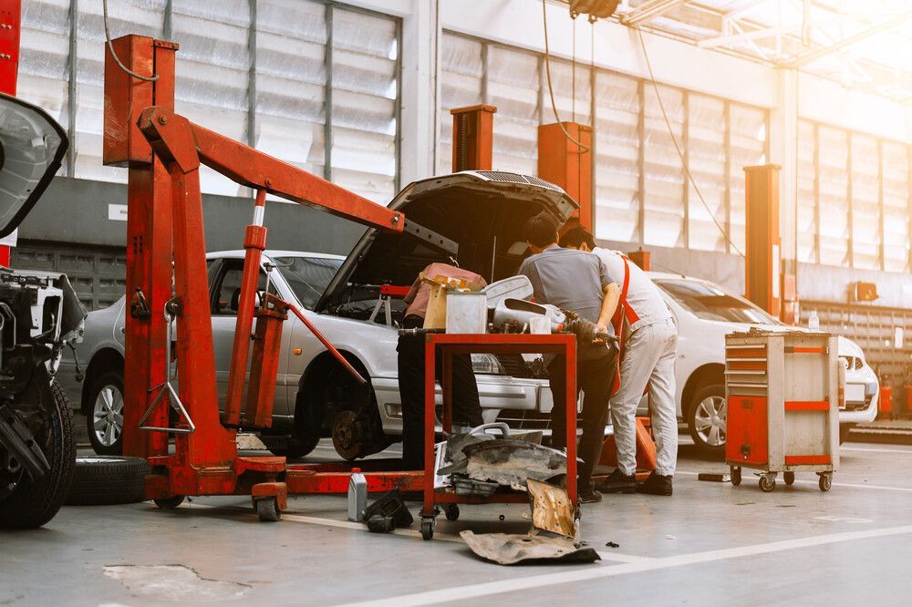 Un hombre está trabajando en un coche en un garaje.