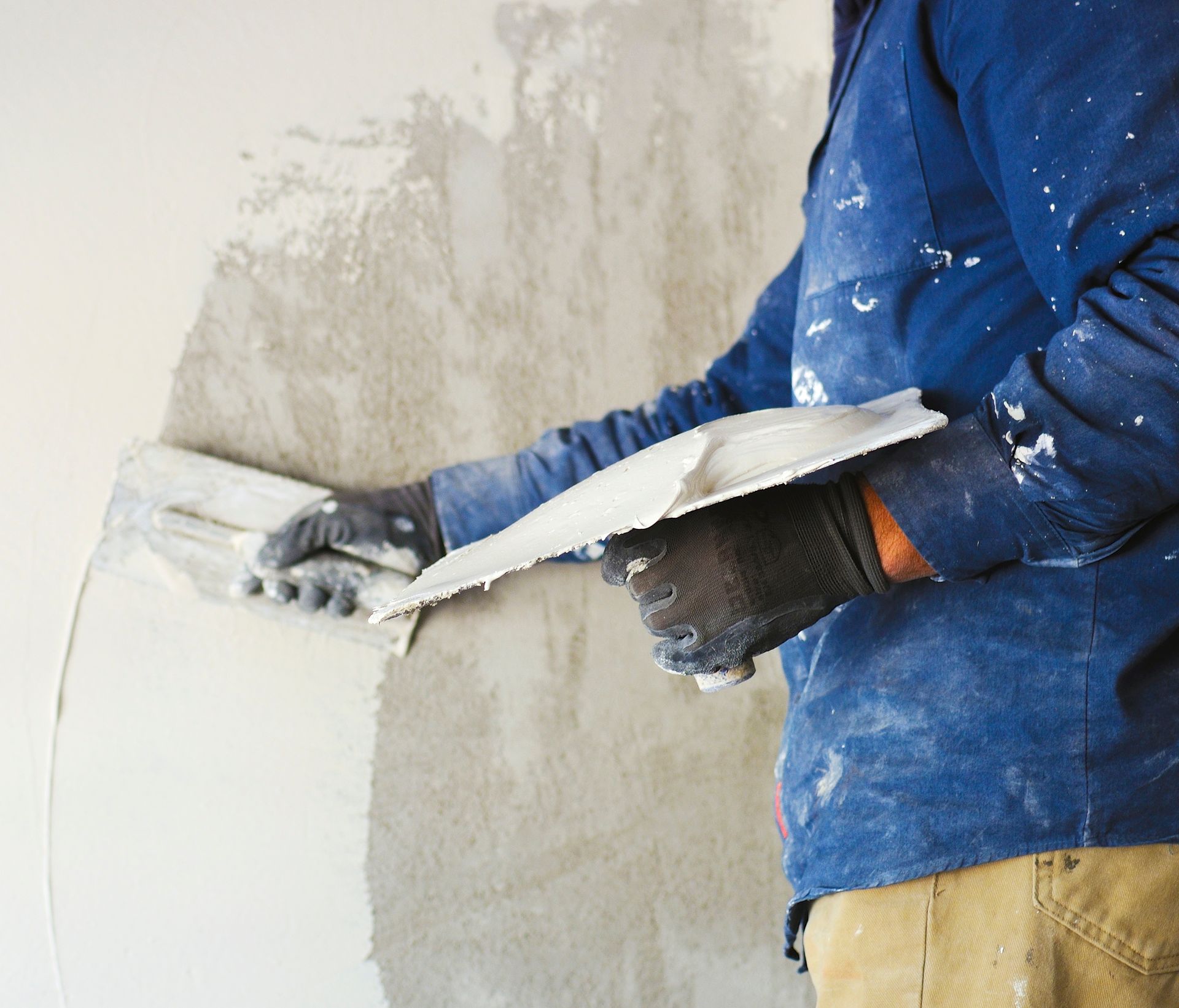 Professionnel appliquant du crépis sur un mur