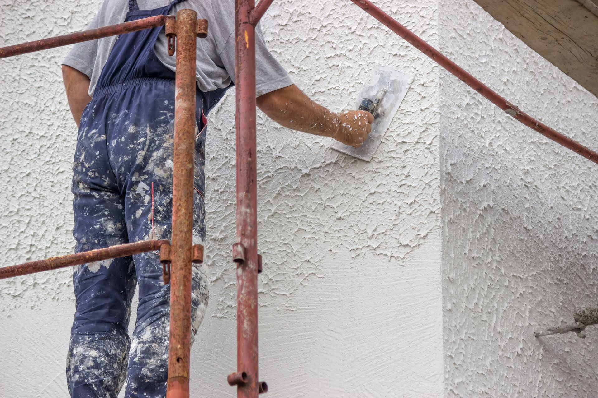 Professionnel qui met du crépit sur une façade