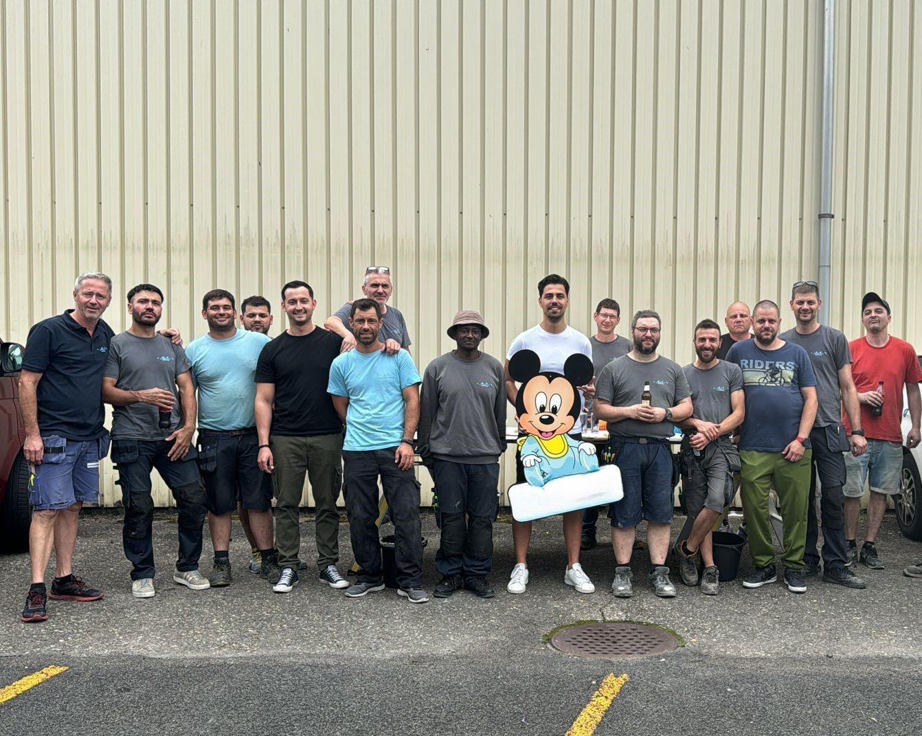 Eine Gruppe Männer posiert vor einem Gebäude für ein Foto.