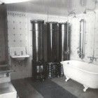 Ein Schwarzweißfoto eines Badezimmers mit Badewanne, Waschbecken und Dusche.