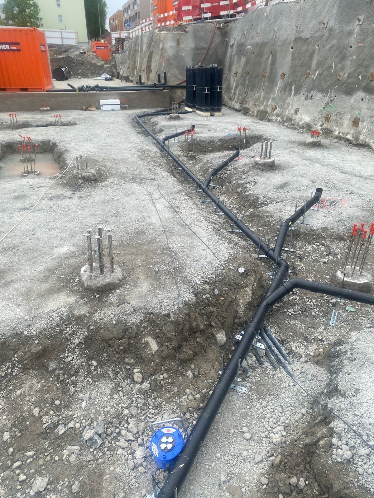 Auf einer Baustelle liegen mehrere Rohre im Boden.