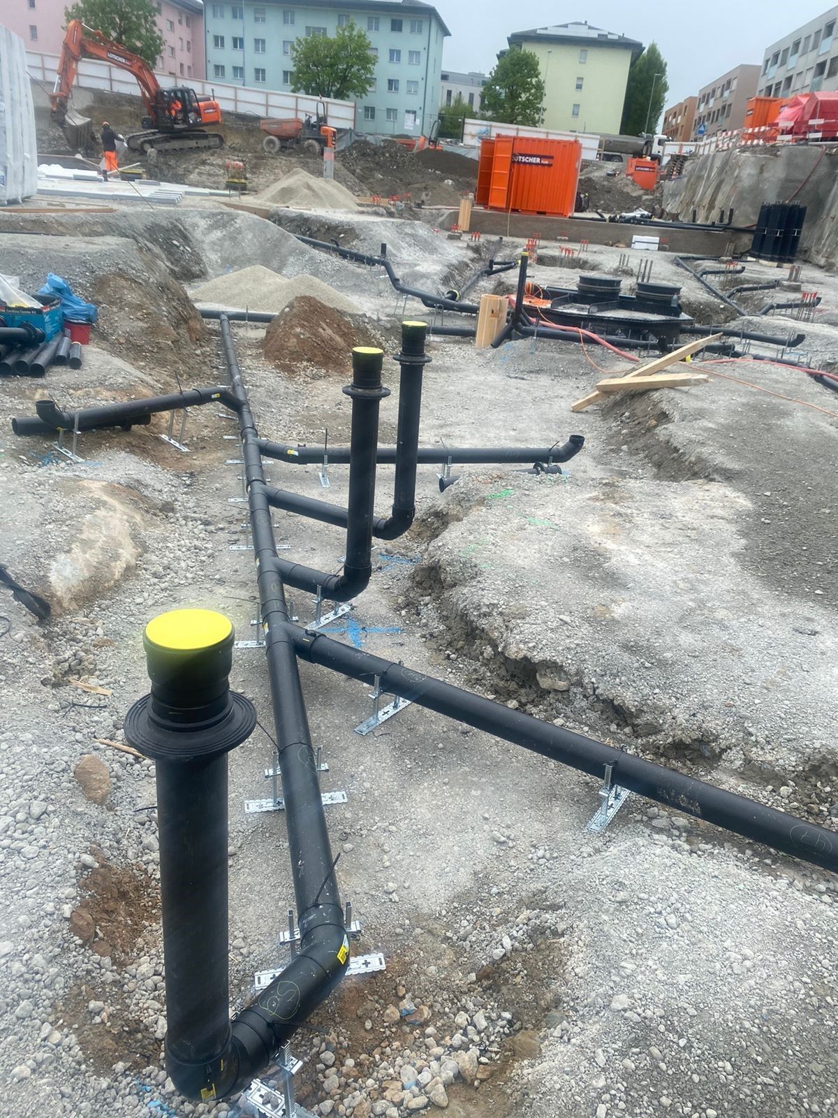 Auf einer Baustelle liegen mehrere Rohre im Boden.