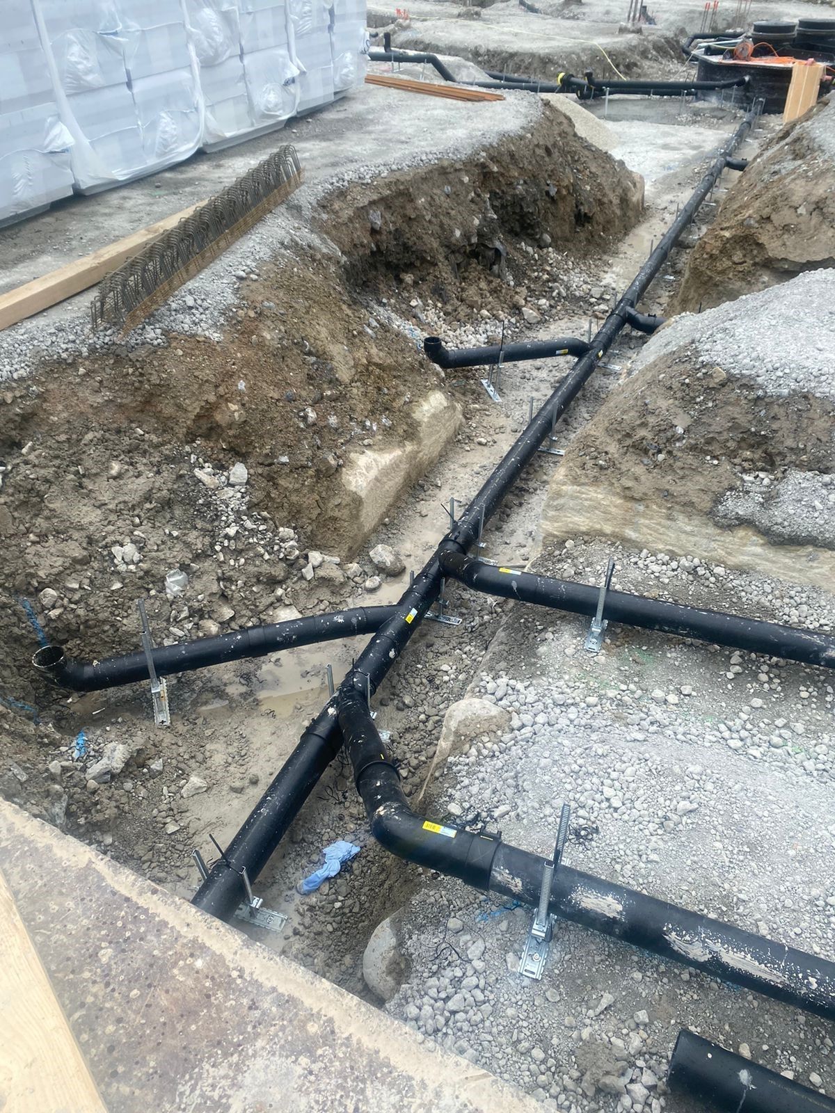 Ein Haufen Rohre liegt im Dreck auf dem Boden.