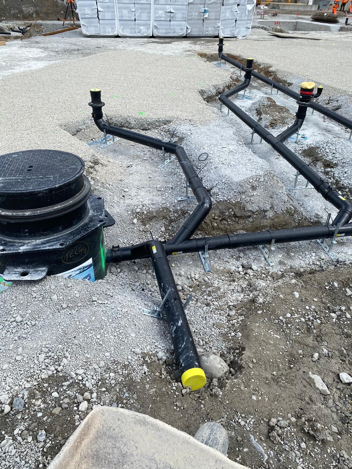 Auf einer Baustelle liegen mehrere Rohre im Boden.