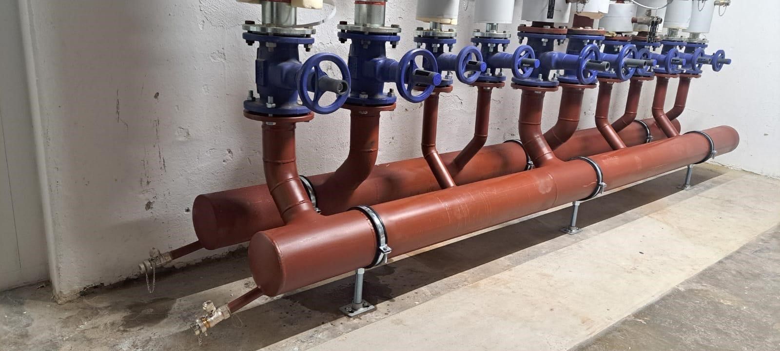 Eine Reihe roter Rohre mit daran befestigten blauen Ventilen.