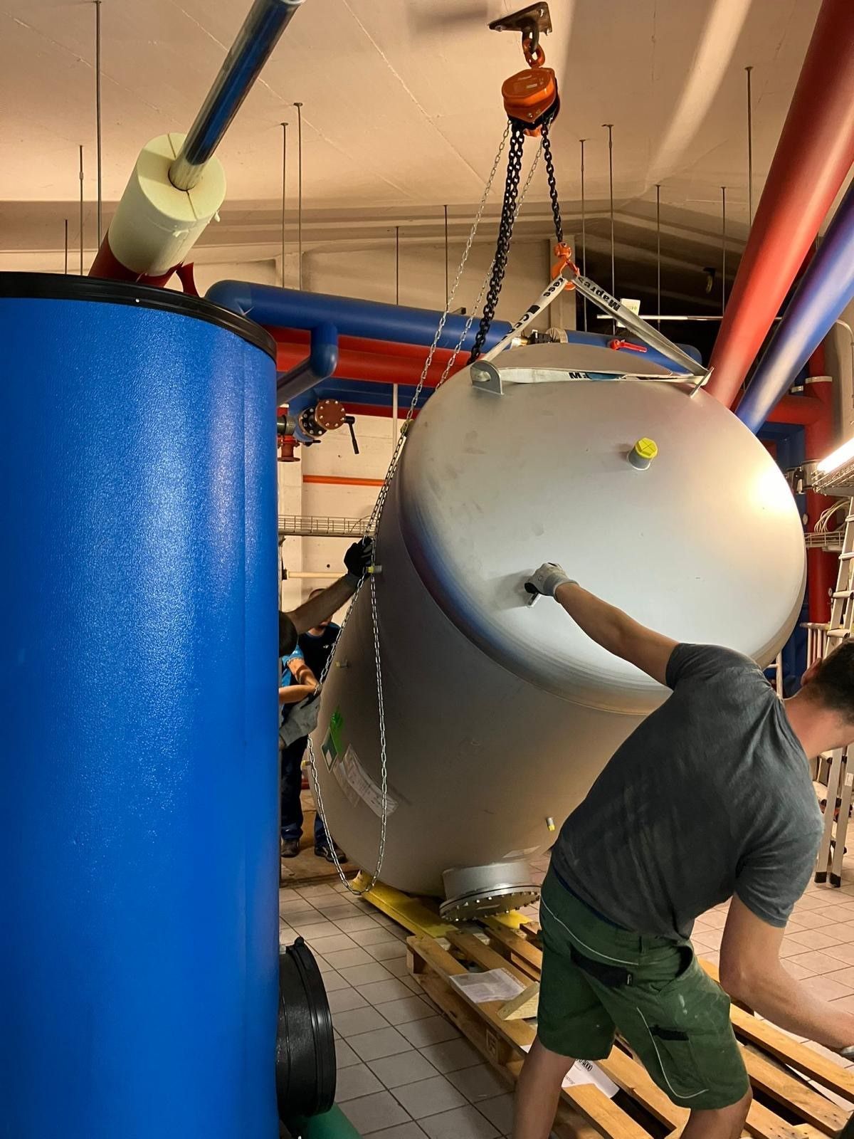 Ein Mann arbeitet in einer Fabrik an einem großen Tank.