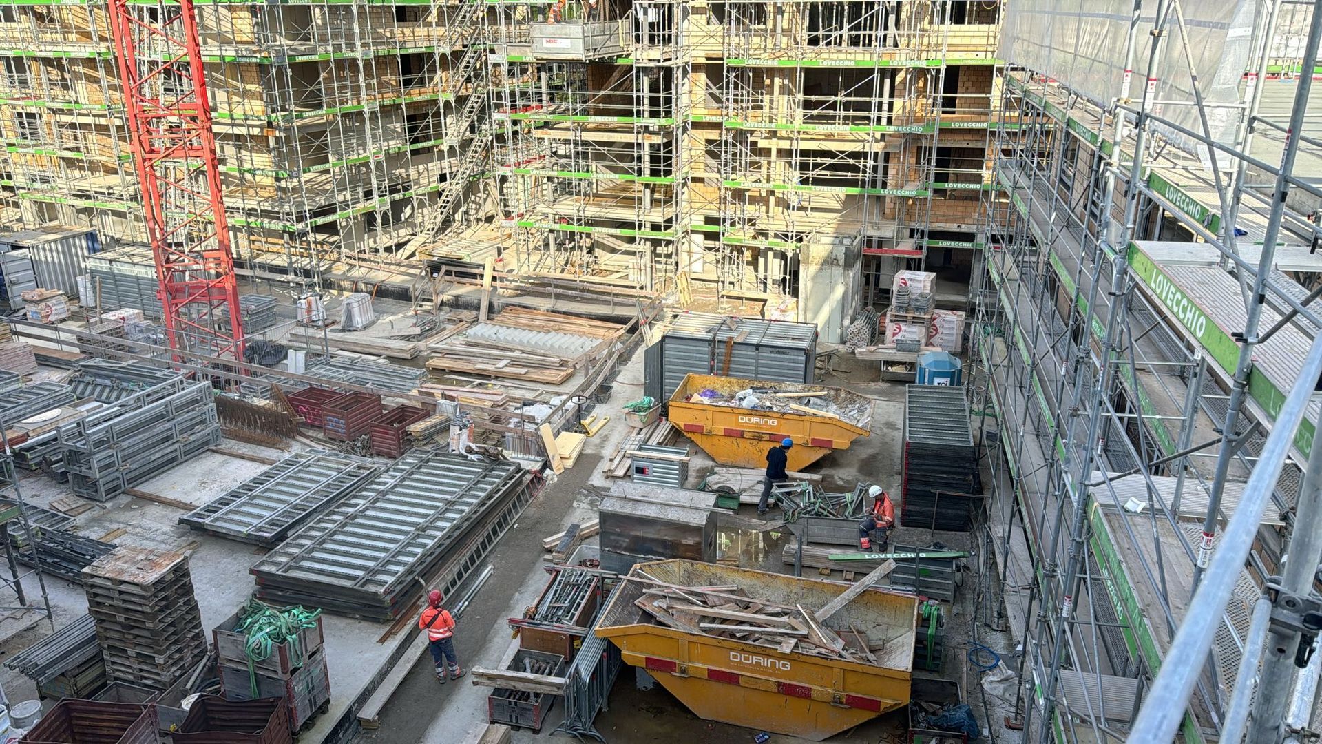 Eine große Baustelle mit vielen Gerüsten und einem Kran.