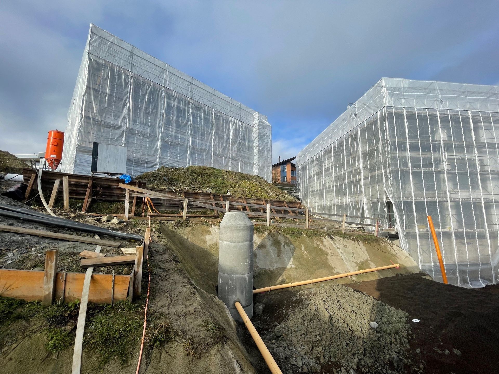 Auf einem Hügel wird ein großes Gebäude errichtet.