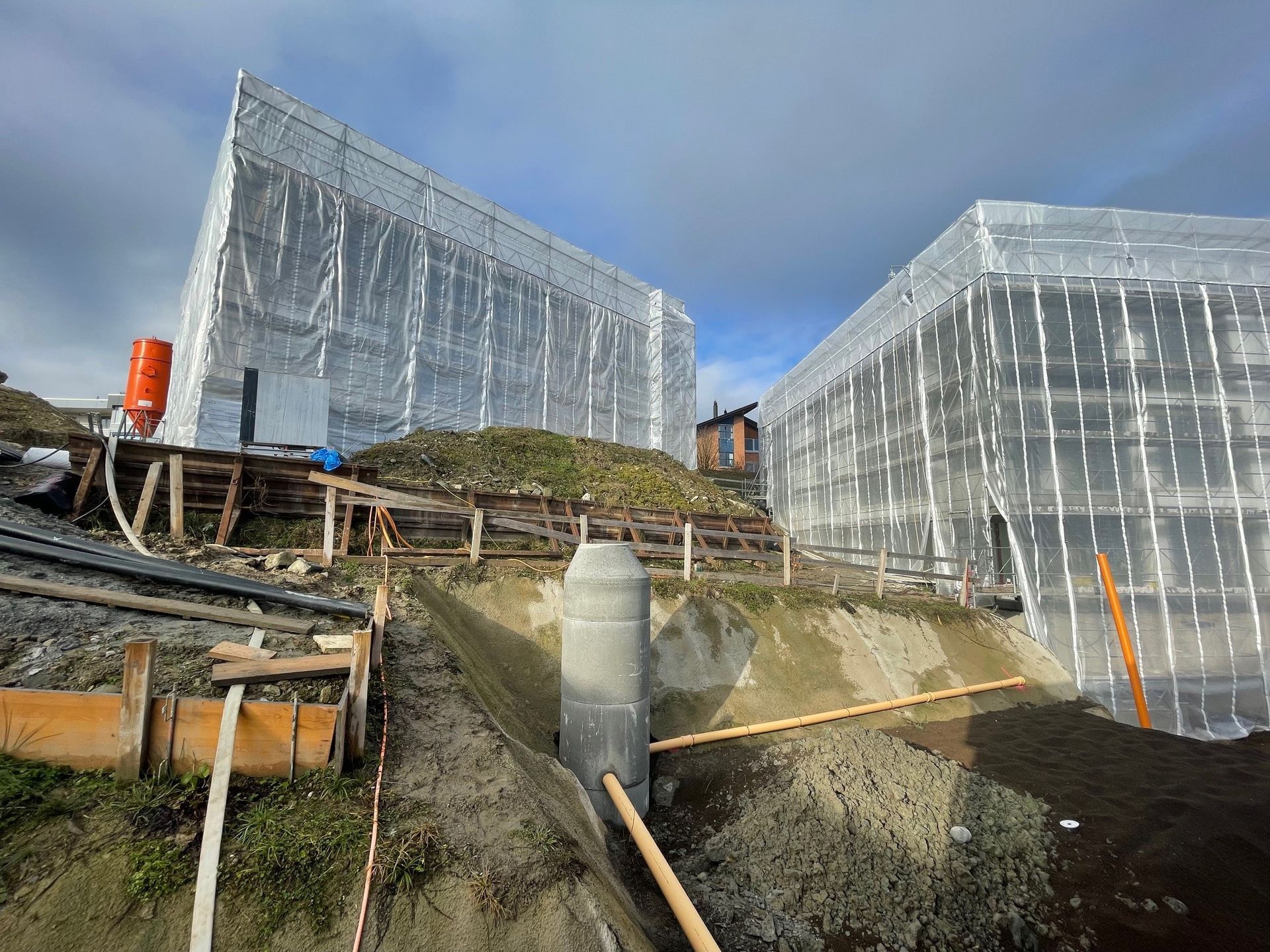 Auf einem Hügel wird ein großes Gebäude errichtet.