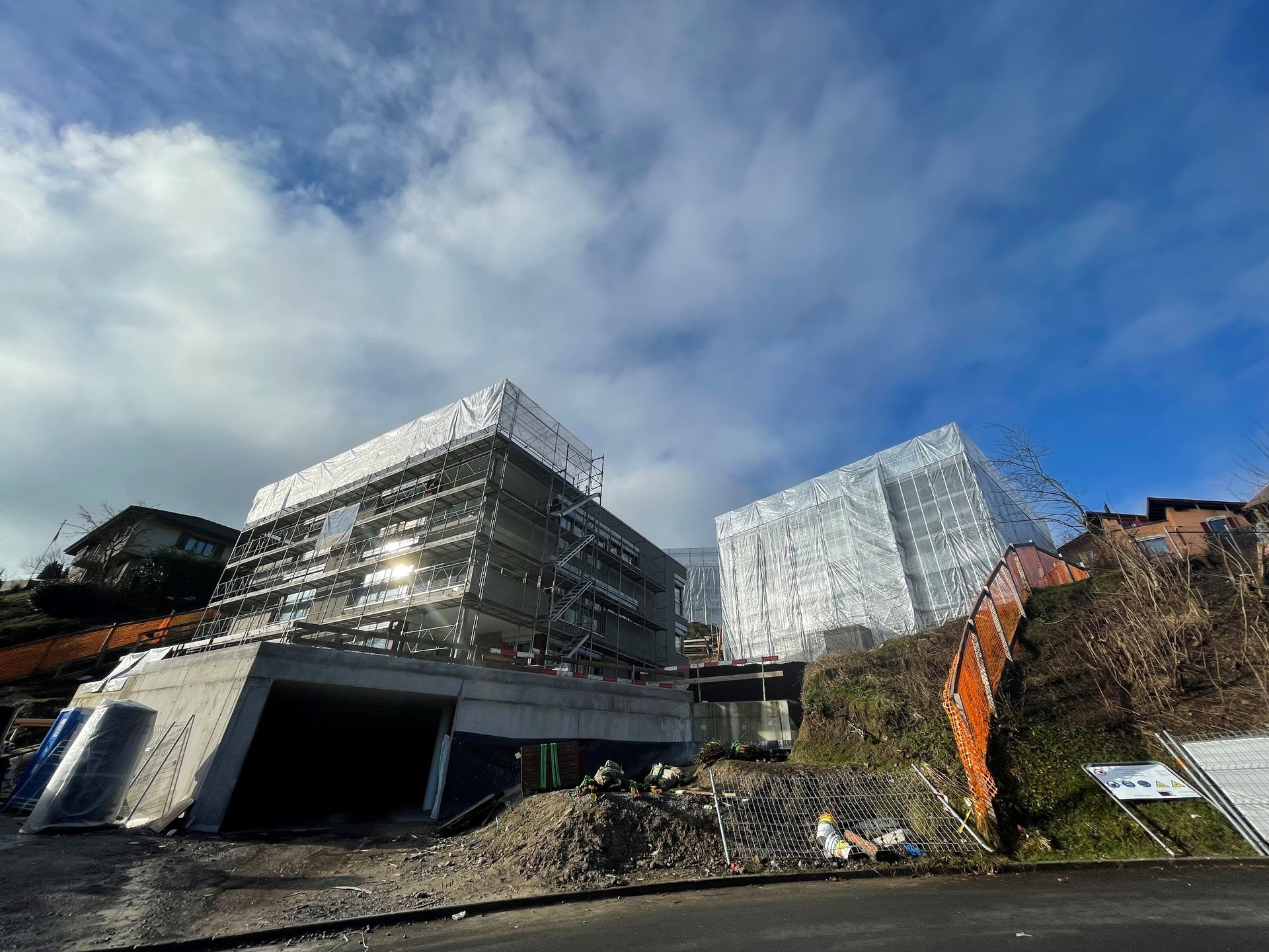 Auf einem Hügel wird ein großes Gebäude errichtet.