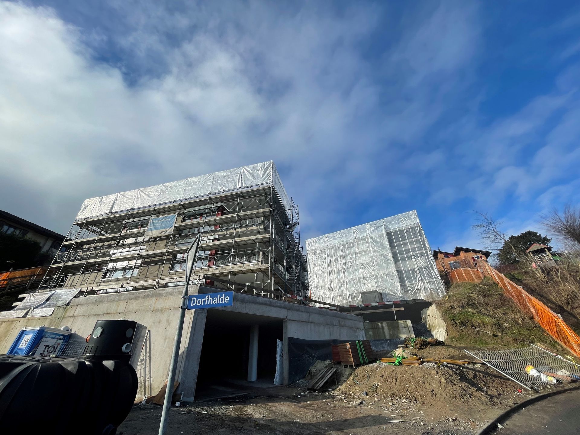 Ein Mann macht ein Foto von einem im Bau befindlichen Gebäude.