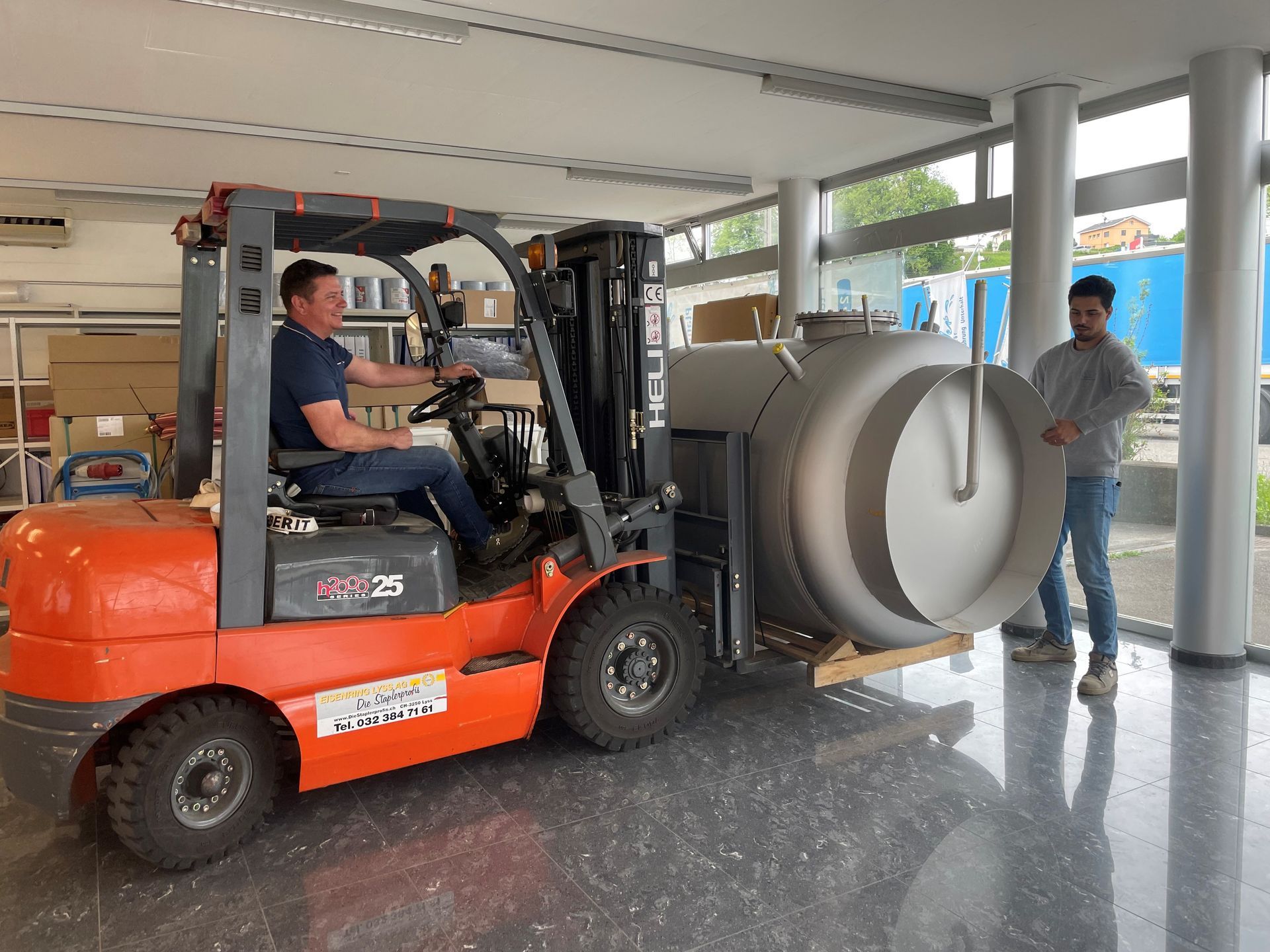 Ein Mann fährt mit einem Gabelstapler in einen Raum.