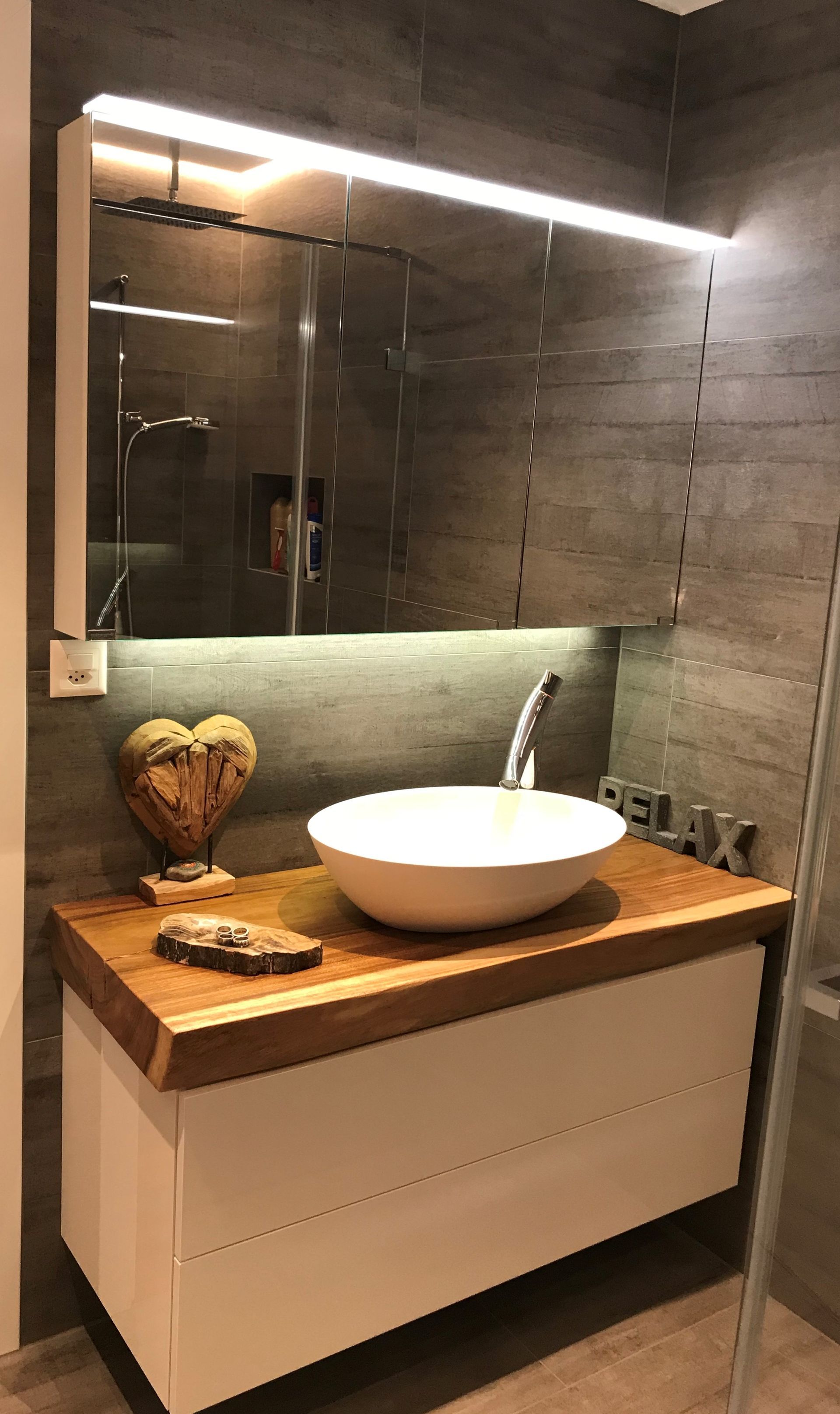 Ein Badezimmer mit Waschbecken und Spiegel an der Wand.