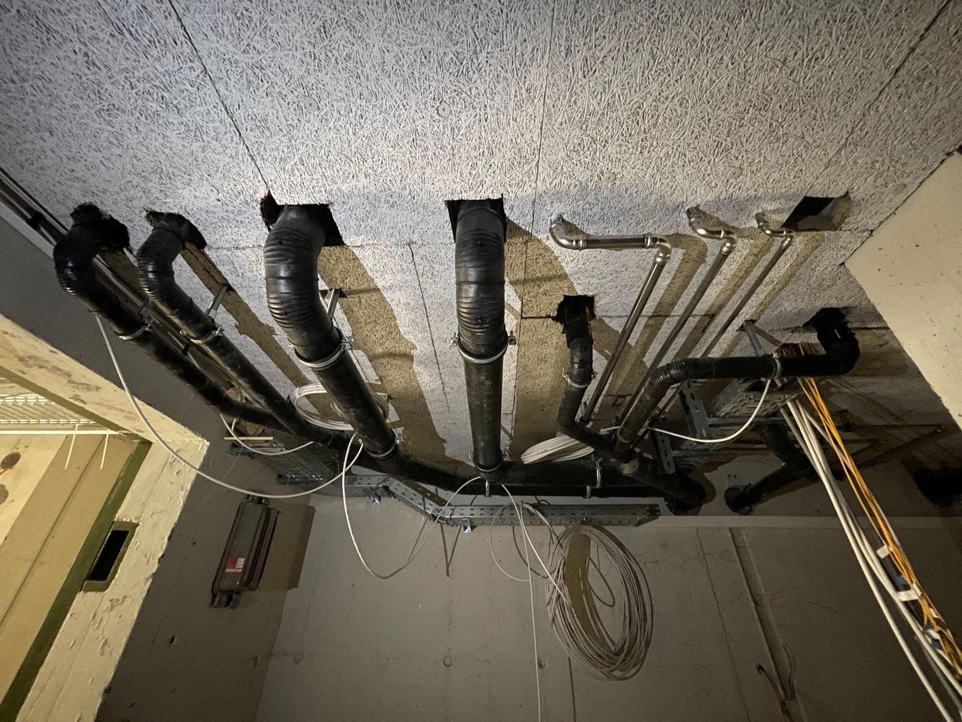 Ein Raum mit vielen Rohren, die von der Decke hängen